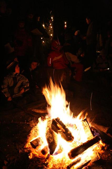 Gemütliches Beisammensein am Feuer, man beachte den Tannenbaum